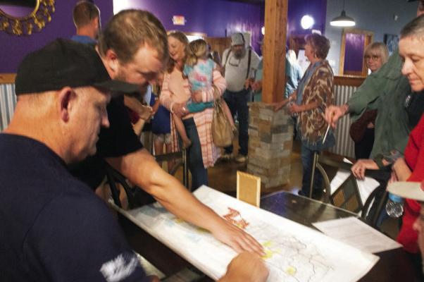 Penelope's Coffee Shop owner Andre Miller points out proposed solar locations on a map to concerned citizens at an anti-solar gathering Saturday in Mount Vernon. Allen D. Fisher